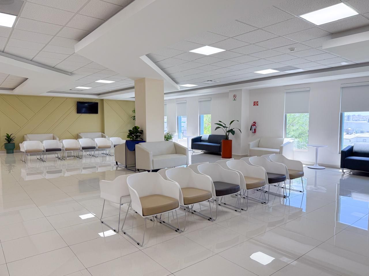 Sala de espera amplia y luminosa, con filas de sillas y ventanales al exterior